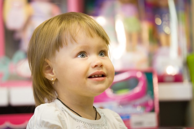 Retrato da menina entre os brinquedos na loja infantil, telefoto