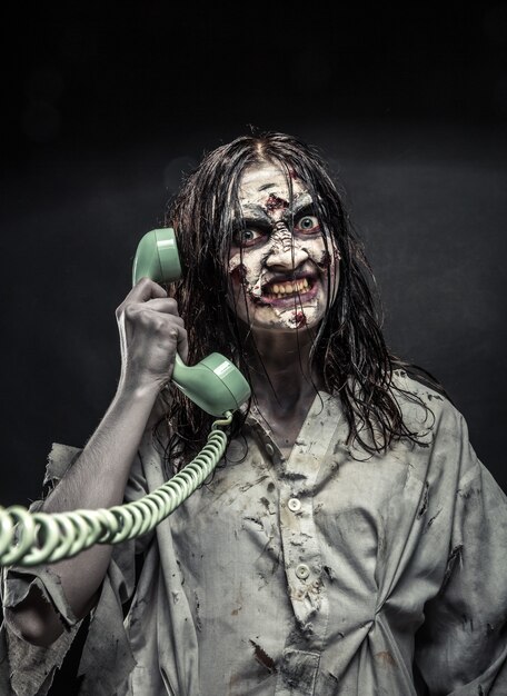 Foto retrato da menina zumbi de terror, chamando por telefone. apavorante