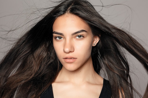 Retrato da moda beleza de youn.eautiful menina morena com cabelo liso preto longo voador.