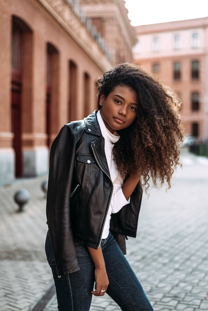 Retrato da moda da mulher com jeans e jaqueta de couro preta.