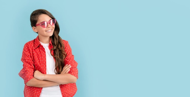 Retrato da moda de criança feliz em óculos de sol e modelo de moda de espaço de cópia de camisa casual