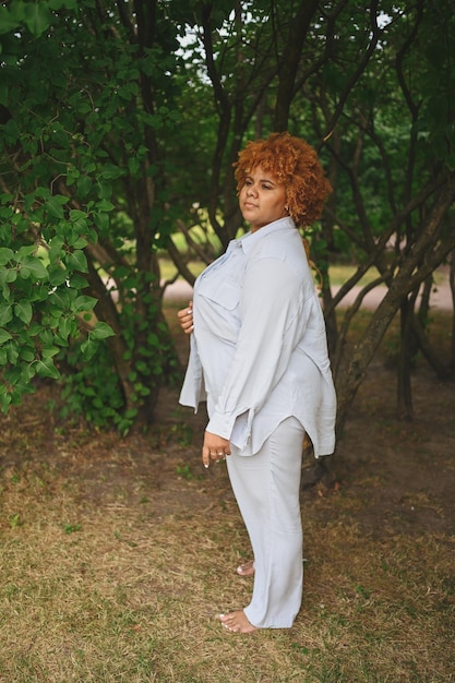 Retrato da moda de jovem mulher afro-americana naturalmente bonita e tamanho em terninho claro