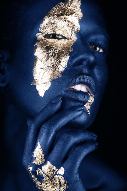 Retrato da moda de uma garota de pele azul com rosto de beleza de maquiagem dourada