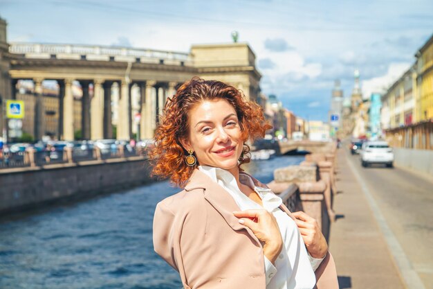 Retrato da moda de uma jovem elegante caminhando ao longo do aterro Dia ensolarado de verão em São Petersburgo