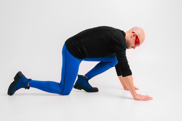Retrato da moda do homem elegante de meia-calça azul e botas de alongamento e exercício.