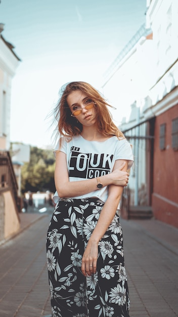 Retrato da moda elegante mulher bonita em óculos de sol posando na cidade moda de rua você fica bem na camiseta branca