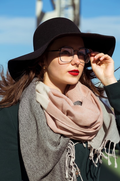 Retrato da moda estilo de vida da adorável modelo morena caminhando na cidade, posando sob a luz do sol