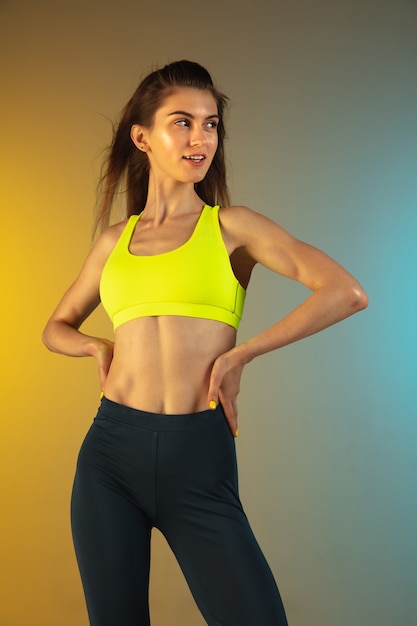 Retrato da moda jovem em forma e mulher esportiva em fundo gradiente, corpo perfeito pronto para