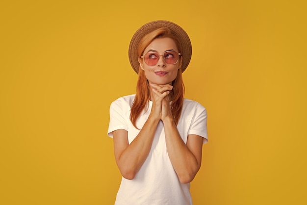 Retrato da moda mulher bonita com chapéu de palha de verão sobre fundo amarelo Sonhando dourado