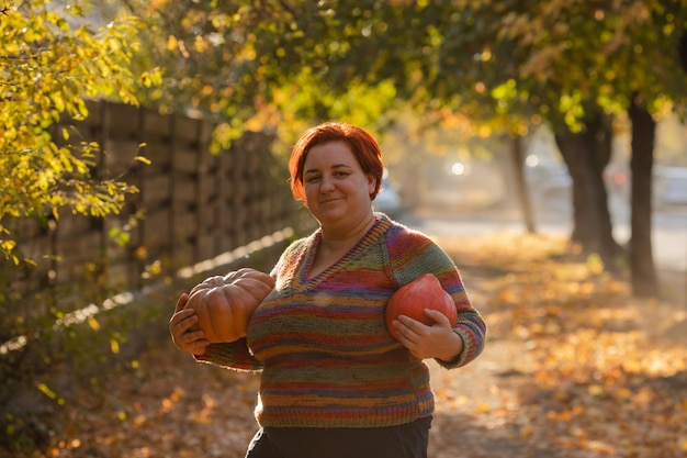 Retrato da mulher feliz do sorriso com abóboras à disposição