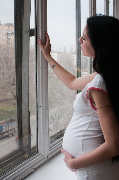 Foto retrato da mulher grávida perto da janela