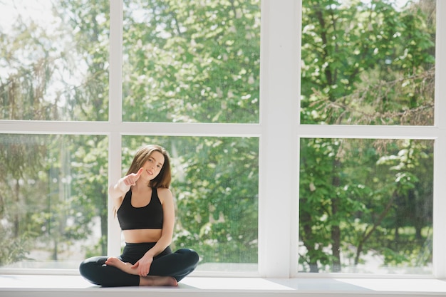 Retrato da senhora treinadora de fitness corporal relaxando entre exercícios na academia