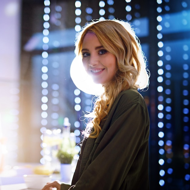 Retrato da vida noturna de festa de uma mulher feliz em uma boate de pé com um sorriso para uma celebração de ano novo Noite de felicidade e senhora com energia batendo e se divertindo em um evento de discoteca social