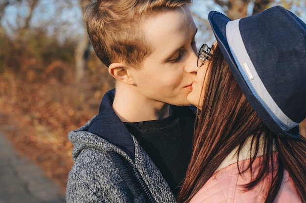 Retrato da vista lateral de um jovem casal caucasiano beijando do lado de fora enquanto namorava em sua viagem de férias.