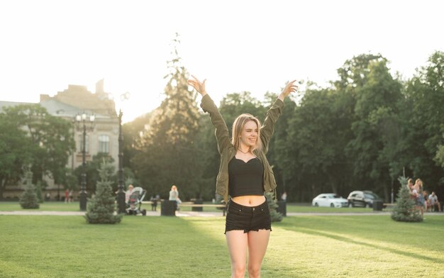 Retrato de dama alegre regocijándose en la victoria en el parque en el césped