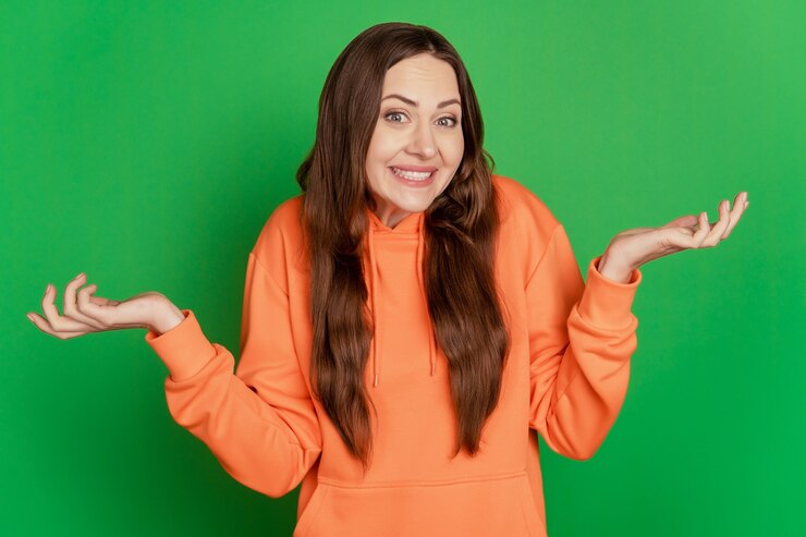 Foto retrato de dama despistada encogerse de hombros cara incierta sobre fondo verde