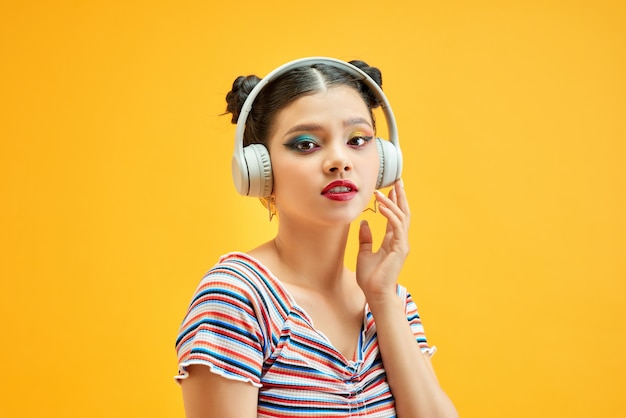 Retrato de dama encantadora, encantadora disfrutar de la música aislada sobre fondo amarillo brillo