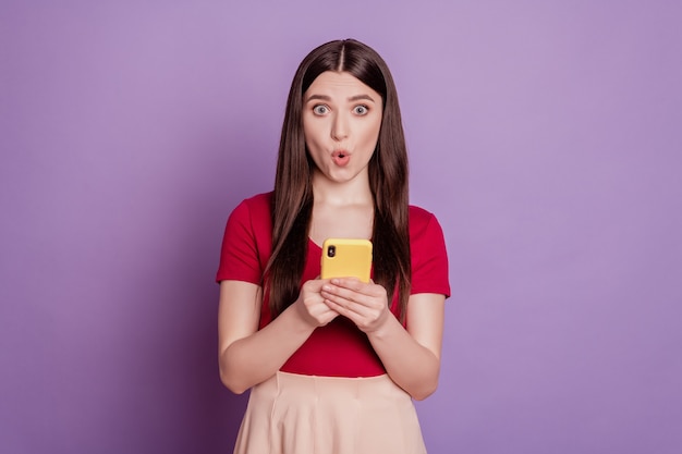 Retrato de dama impresionada asombrada loca mantenga la boca abierta de la cámara de mirada del teléfono sobre fondo violeta