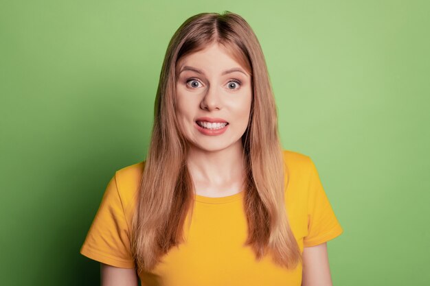 Retrato de dama de niña con problemas reacción error nervioso desgaste camiseta amarilla aislada sobre fondo de color verde