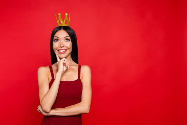 Retrato de dama real mira hacia arriba en la pared de brillo rojo toque el dedo de la mejilla