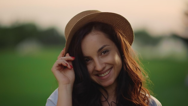 Retrato de dama romántica mirando a la cámara en el parque de verano al atardecer