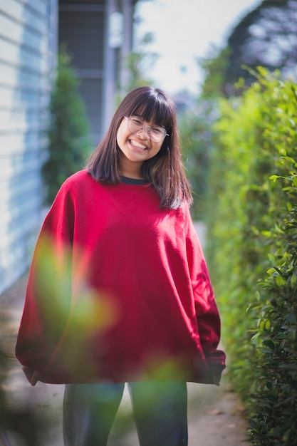 Foto retrato de adolescente asiático usando óculos em pé ao ar livre