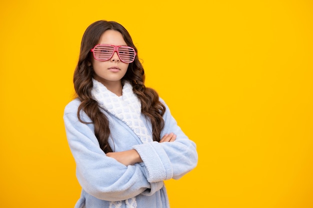 Retrato de adolescente em óculos engraçados e pijama ou roupão de banho em casa se sentindo divertido Festa de pijama infantil