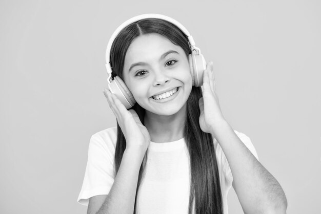 Retrato de adolescente feliz Garota engraçada de 12 13 14 anos de idade, ouça música com fones de ouvido Menina adolescente com fones de ouvido, ouvindo músicas no fone de ouvido Menina sorridente