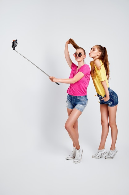 Retrato de adolescentes felizes tomando selfie juntos, isolado no branco - retrato de adolescentes felizes em roupas de verão, óculos de sol, tomando selfie juntos, isolado no branco