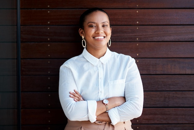 Retrato de agente imobiliário feliz e mulher de negócios, agente imobiliario e empresária no local de trabalho ou braços cruzados, sorriso de rosto e corretora profissional para empresa de construção e propriedade.