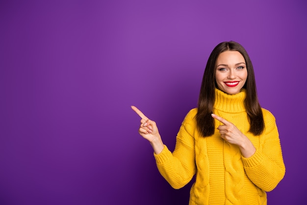 retrato de alegre positivo bonito linda garota apontando para o espaço vazio, sorrindo com os lábios cheios de pomada.