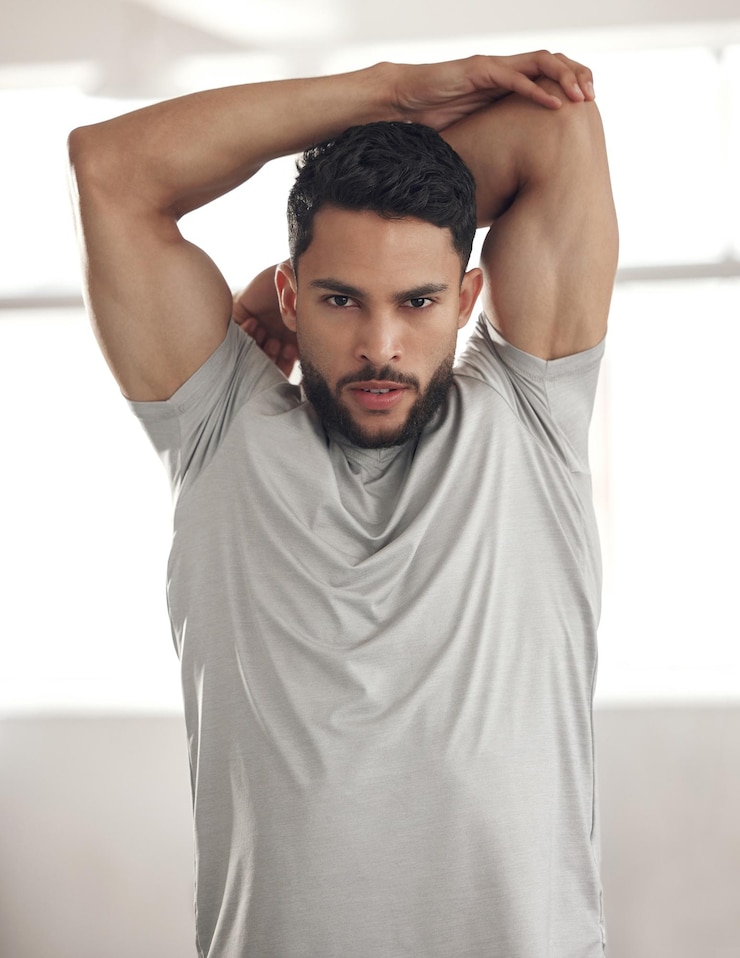 Foto retrato de alongamento e homem com treinamento de fitness e compromisso com objetivos de exercício de rotina e sério pessoa de rosto e atleta com aquecimento centro de bem-estar e esportes com prática e treino