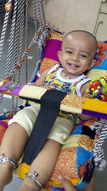 Foto retrato de alto ângulo de bebê sorridente em balanço em casa