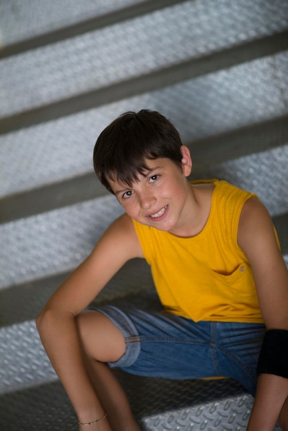 Foto retrato de alto ângulo de um menino adolescente sentado em degraus