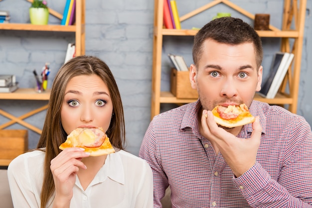 Retrato de amantes comendo pizza