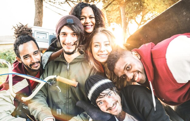 Foto retrato de amigos alegres contra as árvores durante o pôr-do-sol