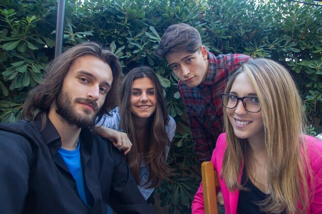 Foto retrato de amigos contra plantas no parque