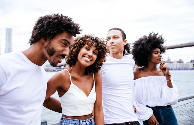 Retrato de amigos felizes de pé contra o céu