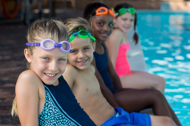 Retrato de amigos sentados à beira da piscina