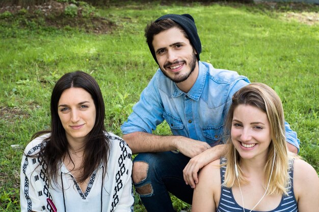 Foto retrato de amigos sorridente sentados na grama