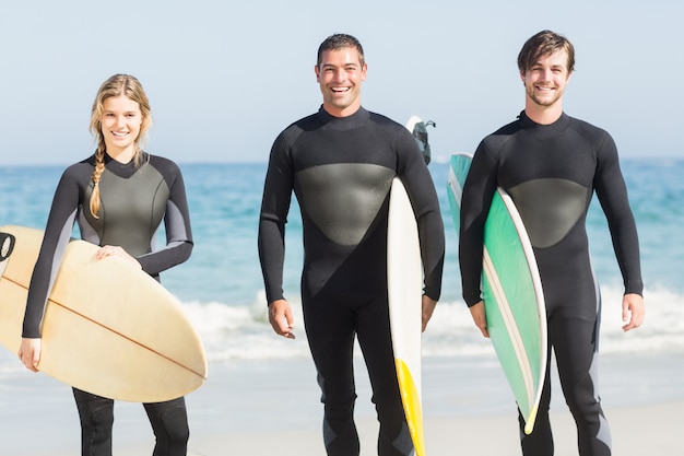 Retrato de amigos surfistas com pé de prancha de surf na praia