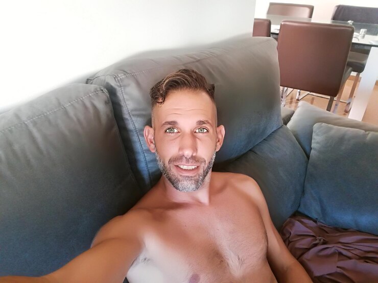 Foto retrato de ângulo alto de um homem sem camisa sentado no sofá em casa