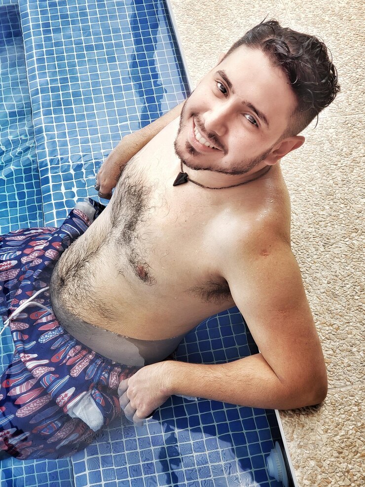 Foto retrato de ângulo alto de um jovem sem camisa relaxando na piscina