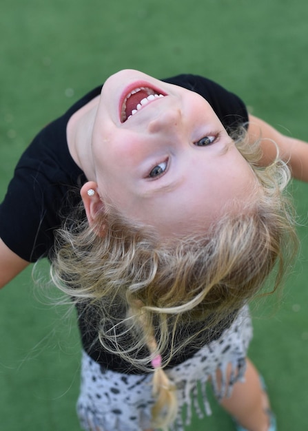 Retrato de ângulo alto de uma menina brincalhona de pé no playground