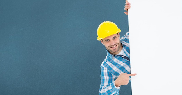 Retrato de arquiteto masculino sorridente apontando outdoor em pé contra um fundo azul
