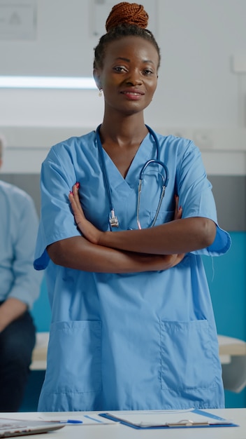 Retrato de assistente médico vestindo uniforme em pé no armário