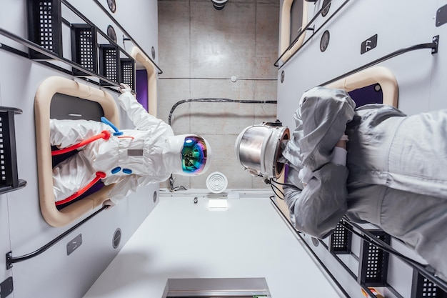 Retrato de astronautas em trajes espaciais no módulo de dormir do hotel cápsula vista de baixo