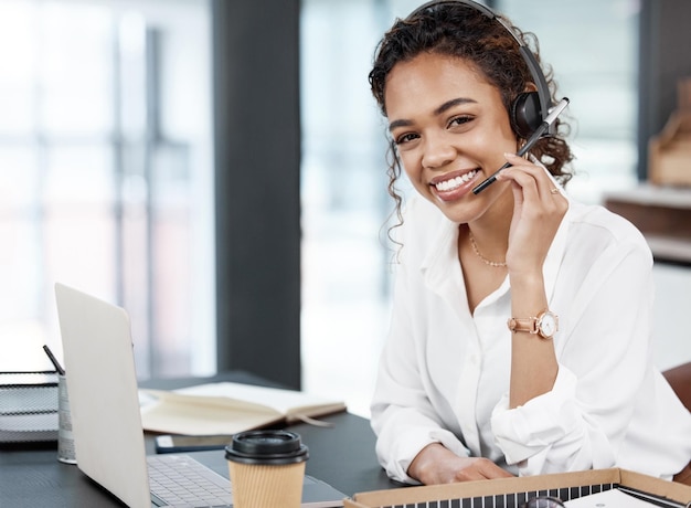 Retrato de atendimento ao cliente de mulher com fones de ouvido e laptop em sua mesa em um escritório de seu local de trabalho Telemarketing ou comunicação on-line de call center e pessoa do sexo feminino em seu espaço de trabalho