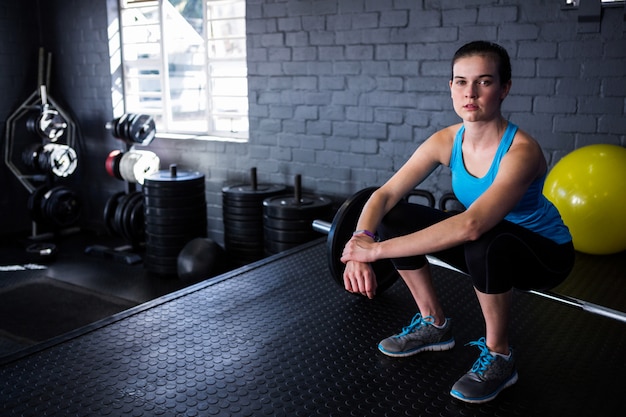 Retrato de atleta feminina sentada na barra