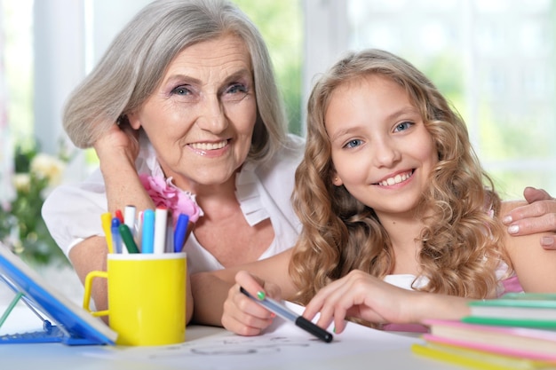 Retrato de avó e neta desenhando juntos